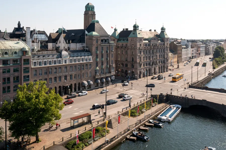 Hotellbyggnaden sedd uppifrån vid kanalen med gata, bro och båtar utanför