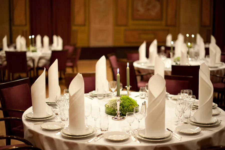 Dukat bord med vikta servetter, glas och porslin