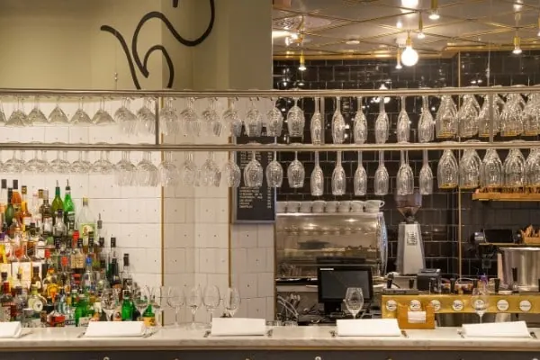 Bar med flaskhyllor och glas hängande över disken