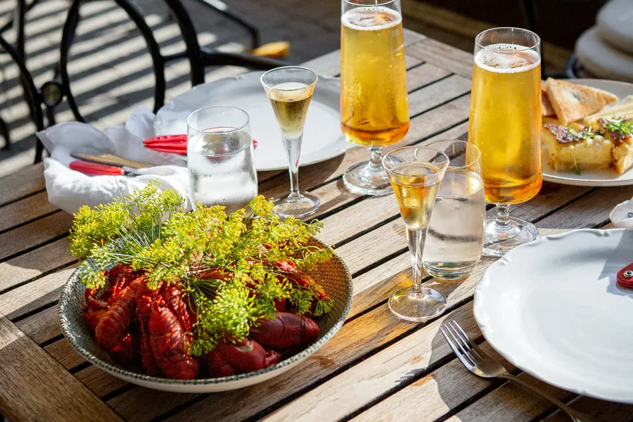 Kräftor och tillbehör uppdukade på ett bord utomhus
